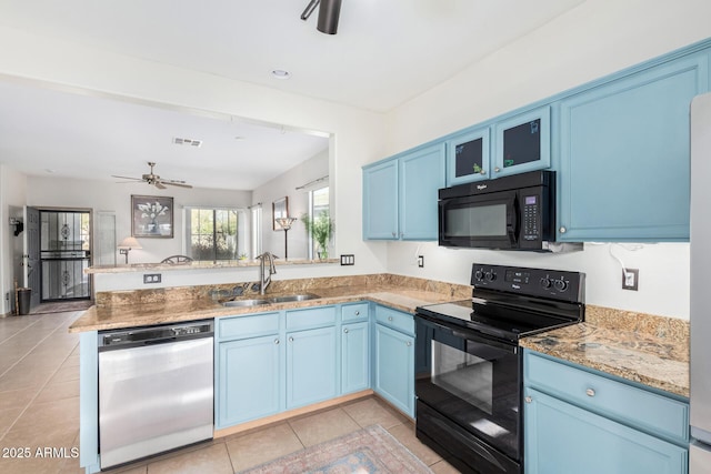 kitchen featuring black appliances, blue cabinetry, and a sink