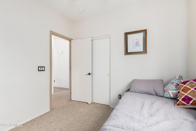 bedroom with light carpet and a closet