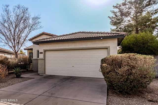 view of front of home featuring concrete driveway, a tiled roof, and stucco siding