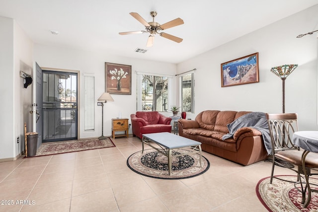 living area with visible vents, a ceiling fan, and light tile patterned flooring