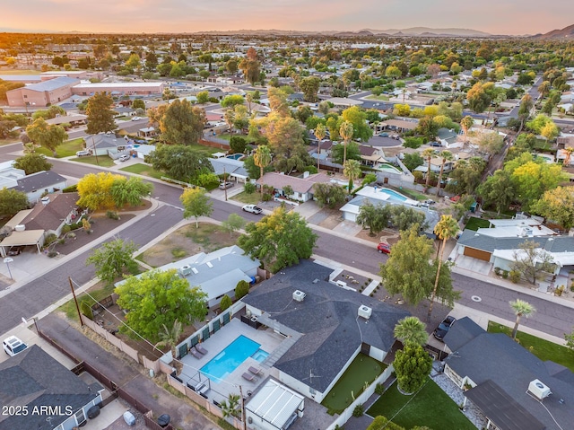 aerial view at dusk featuring a mountain view and a residential view