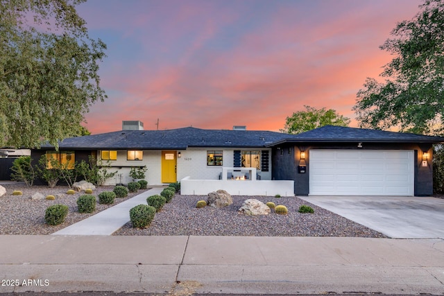ranch-style home with concrete driveway and an attached garage