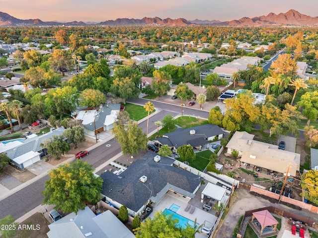 aerial view at dusk featuring a mountain view and a residential view