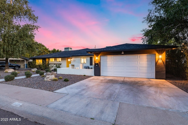 ranch-style home featuring concrete driveway and a garage
