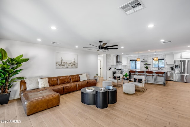 living area with ceiling fan, recessed lighting, light wood-style flooring, and visible vents