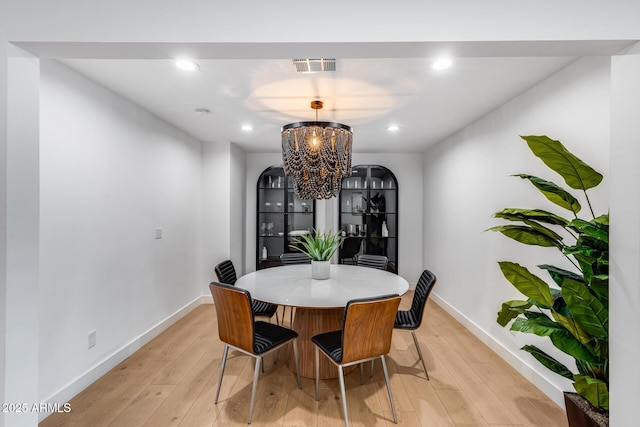 dining room featuring an inviting chandelier, baseboards, light wood-style floors, and visible vents