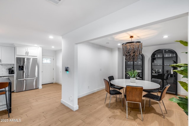 dining space featuring recessed lighting, baseboards, an inviting chandelier, and light wood-style floors