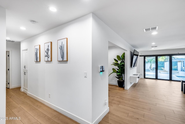 hallway with recessed lighting, baseboards, light wood finished floors, and visible vents