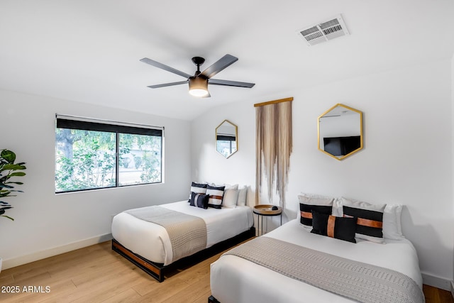 bedroom featuring a ceiling fan, baseboards, visible vents, and light wood-type flooring