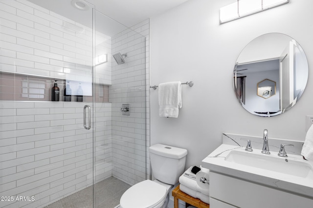 bathroom featuring vanity, toilet, and a stall shower