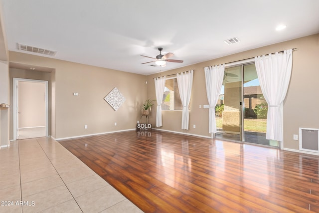 empty room featuring light wood-type flooring, ceiling fan, and a wealth of natural light