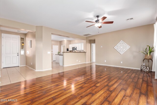 unfurnished living room featuring light hardwood / wood-style floors and ceiling fan