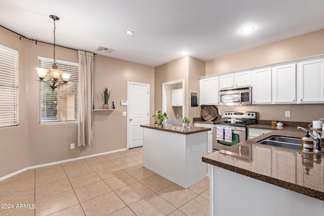 kitchen featuring white cabinets, hanging light fixtures, a kitchen island, an inviting chandelier, and stainless steel appliances