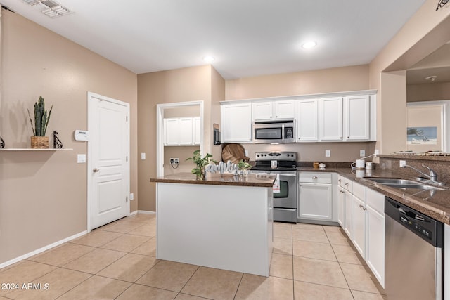 kitchen featuring light tile patterned flooring, appliances with stainless steel finishes, sink, and white cabinetry