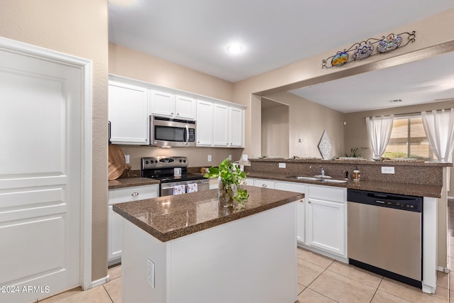 kitchen with a center island, stainless steel appliances, and white cabinets