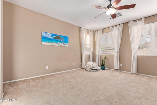 interior space with ceiling fan and light carpet