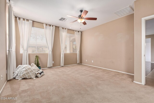 interior space featuring light carpet and ceiling fan