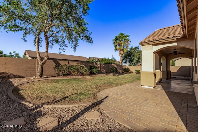 view of yard with ceiling fan and a patio area