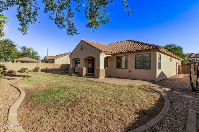 rear view of house with a lawn and a patio area