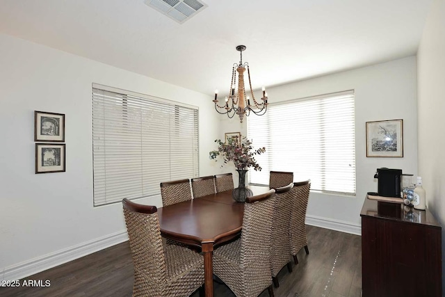 dining room with dark wood-type flooring and a chandelier