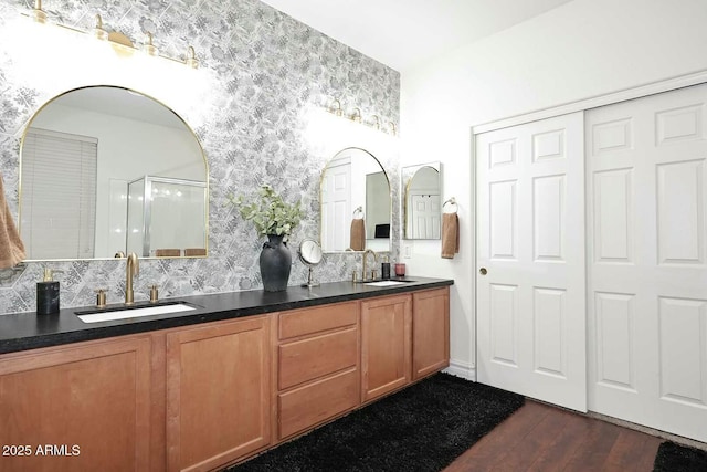 bathroom with tasteful backsplash, wood-type flooring, walk in shower, and vanity