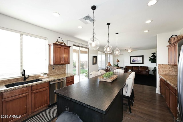 kitchen featuring dark wood-type flooring, sink, tasteful backsplash, a center island, and dishwasher