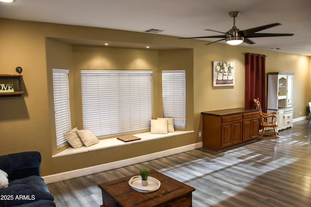 living room featuring ceiling fan and dark wood-type flooring