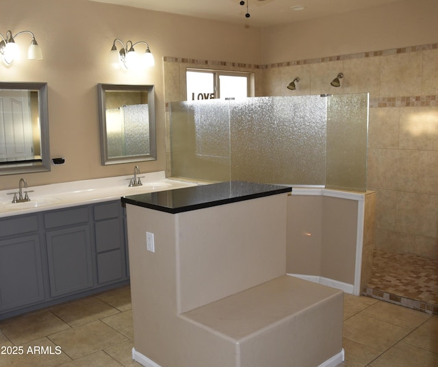 bathroom with tile patterned flooring, vanity, and a shower