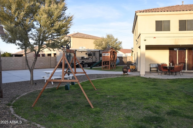 view of yard featuring a playground and a patio