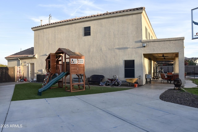 back of house with a playground, a patio area, and central AC unit