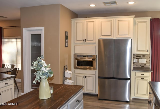 kitchen with stainless steel appliances, butcher block countertops, tasteful backsplash, and dark hardwood / wood-style floors