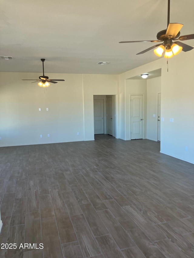 spare room with dark wood-style floors, visible vents, and a ceiling fan