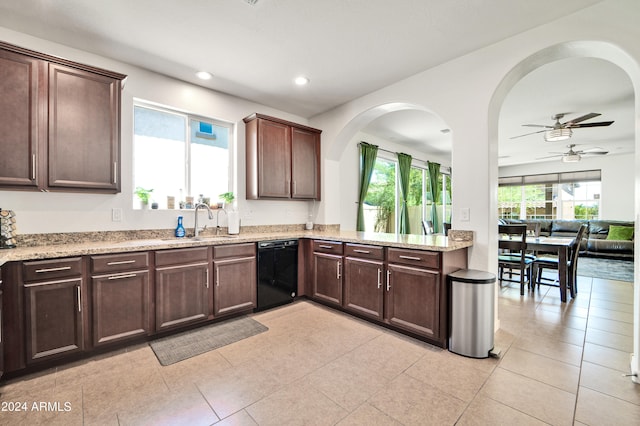 kitchen with black dishwasher, light tile patterned floors, ceiling fan, light stone counters, and dark brown cabinetry