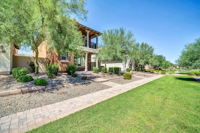 view of front of home featuring a front lawn and a balcony