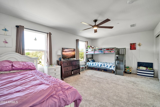 carpeted bedroom featuring ceiling fan and multiple windows