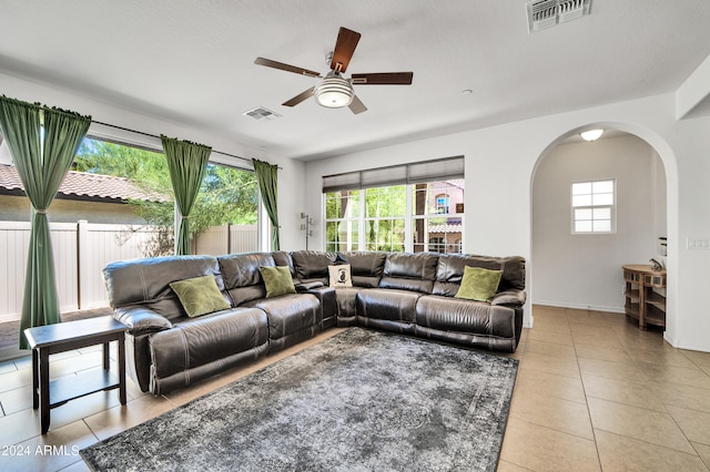 tiled living room featuring ceiling fan and a textured ceiling