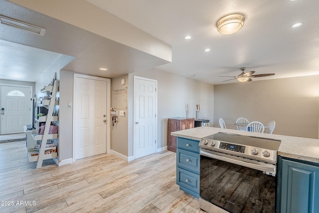 kitchen with visible vents, blue cabinetry, stainless steel electric range, light countertops, and light wood-type flooring