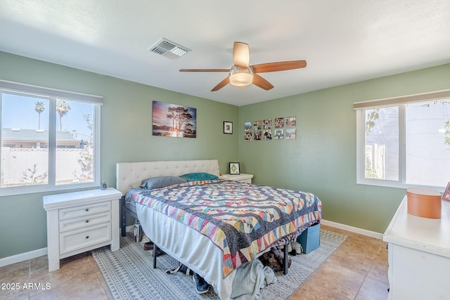 bedroom featuring light tile patterned floors, visible vents, baseboards, and a ceiling fan