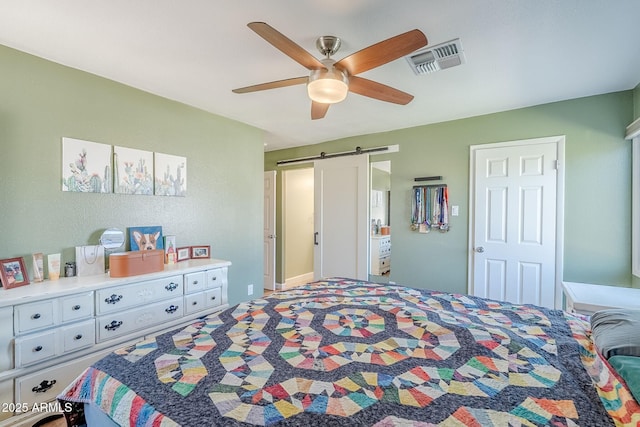 bedroom with a barn door, a ceiling fan, and visible vents