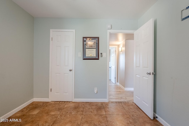 unfurnished bedroom featuring light tile patterned flooring and baseboards