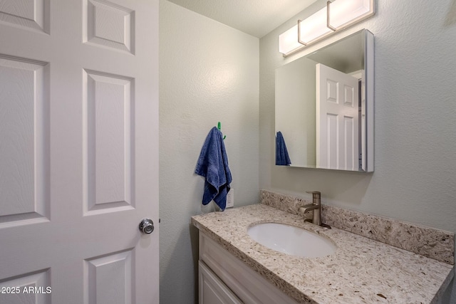 bathroom with vanity and a textured wall