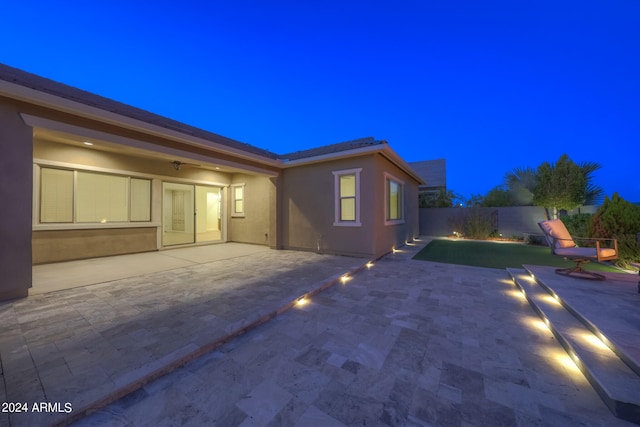 property exterior at twilight featuring a patio area