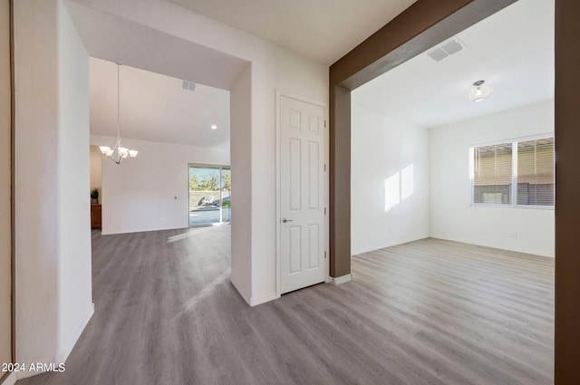 unfurnished room with light hardwood / wood-style flooring and an inviting chandelier