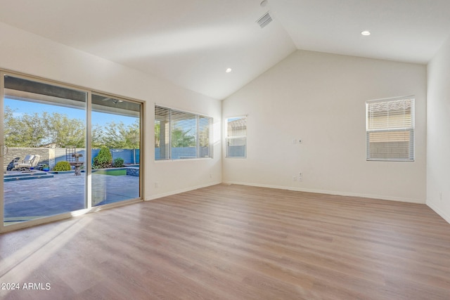 unfurnished room featuring vaulted ceiling and light hardwood / wood-style flooring