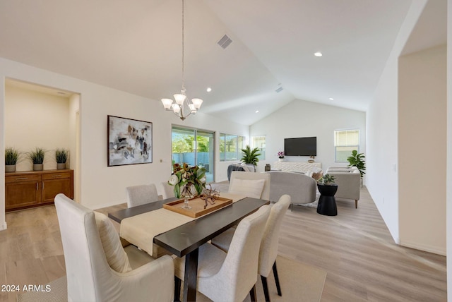 dining room featuring light hardwood / wood-style flooring, vaulted ceiling, and a healthy amount of sunlight