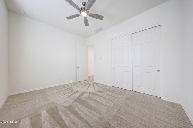 unfurnished bedroom with a closet, ceiling fan, and light carpet