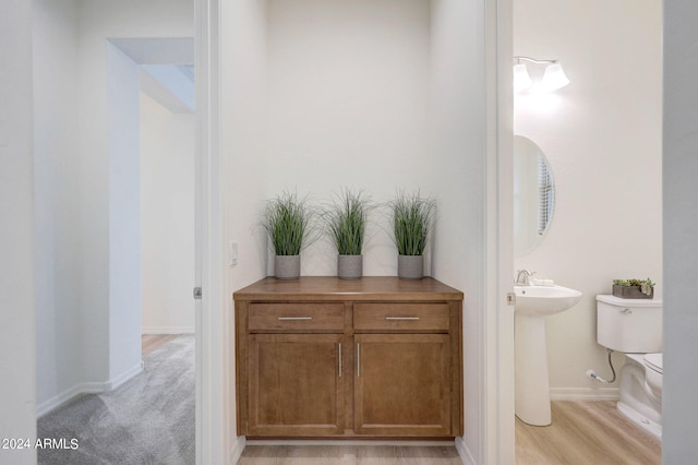 bathroom with toilet and hardwood / wood-style flooring