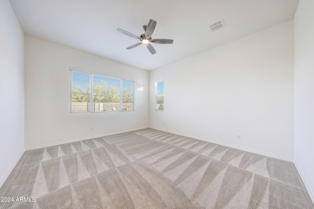 empty room featuring ceiling fan and light carpet