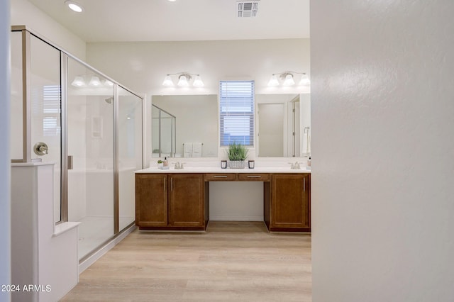 bathroom with a shower with door, vanity, and hardwood / wood-style floors