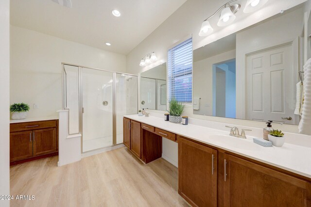 bathroom with walk in shower, hardwood / wood-style flooring, and vanity